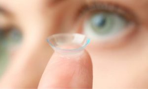 lady about to put contact lens in eye 