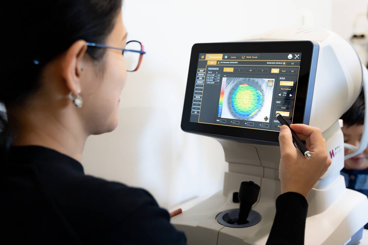 optometrist conducting an eye test on a child